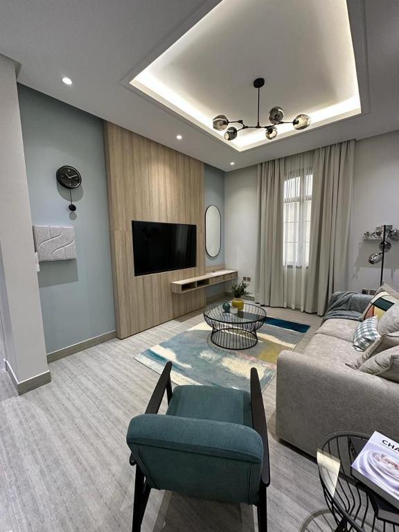 - un salon avec un canapé et une télévision dans l'établissement Modern Appartements With Private Entry, à Riyad