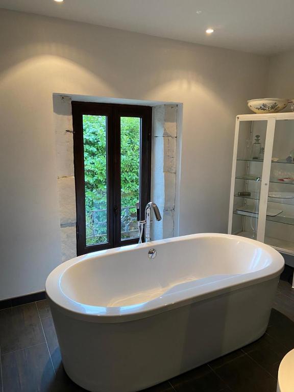 a large white tub in a bathroom with a window at Mas carita in Cabannes