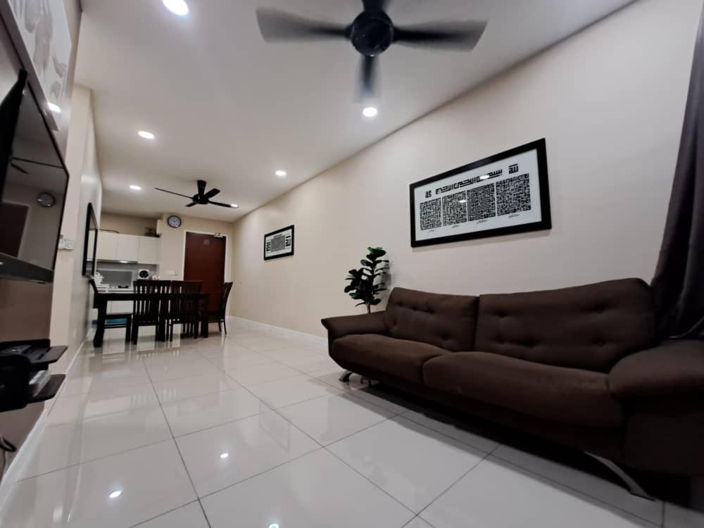 uma sala de estar com um sofá e uma ventoinha de tecto em Hijauan Homestay Shah Alam em Shah Alam