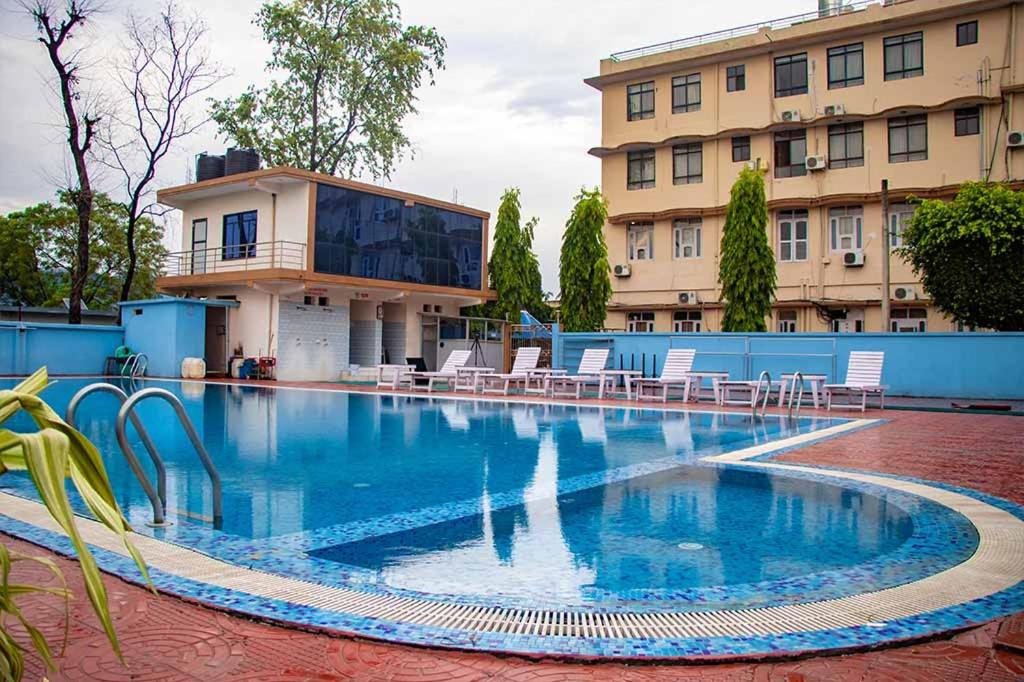 a large swimming pool in front of a building at Hotel Opera in Bahāsi