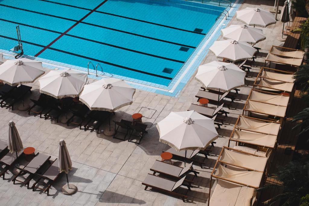 uma vista superior para uma piscina com cadeiras e guarda-sóis em Neve Eilat Hotel Former Nova By Atlas Hotels em Eilat