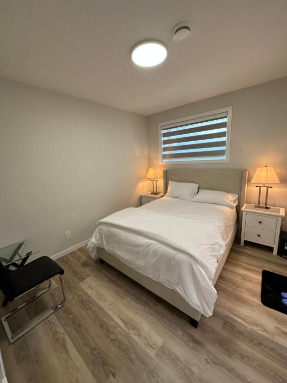 sypialnia z łóżkiem, 2 stołami i oknem w obiekcie 2 Bedroom 2 Washrooms Brand New Beautiful & Cozy Suite w mieście Calgary