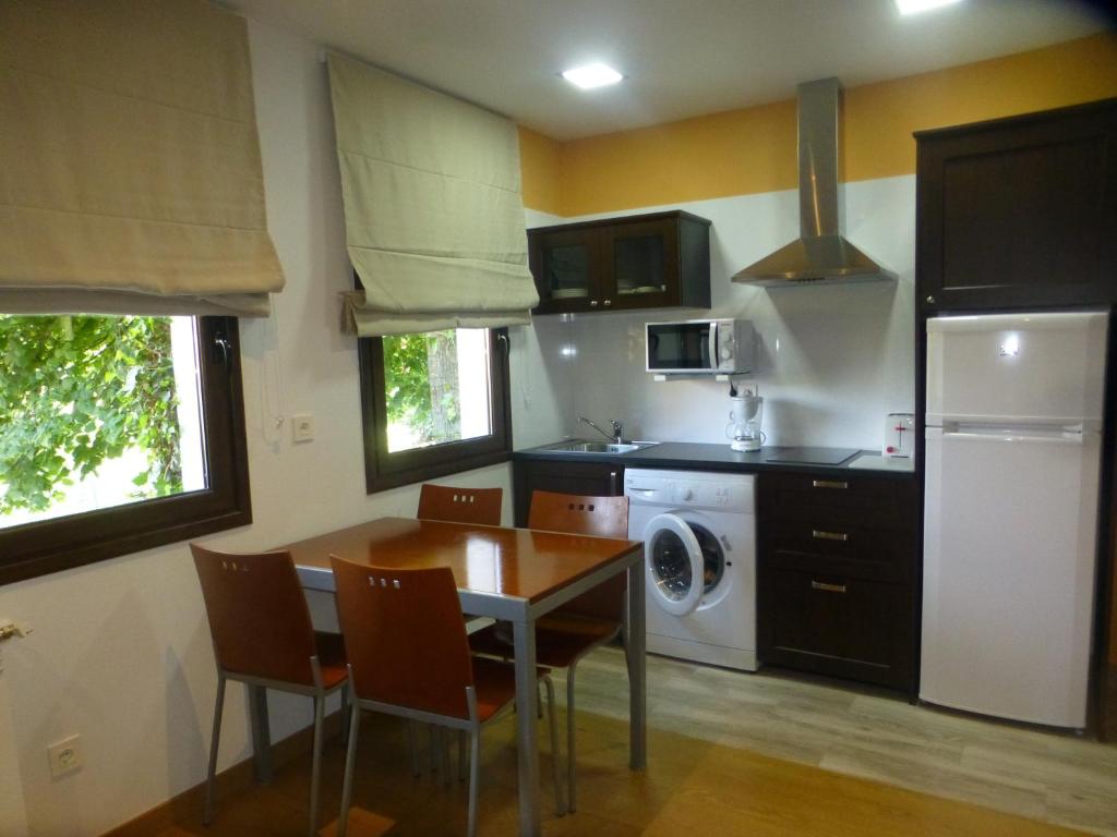 a kitchen with a table and chairs and a refrigerator at La Casina de Torra in Ribadesella