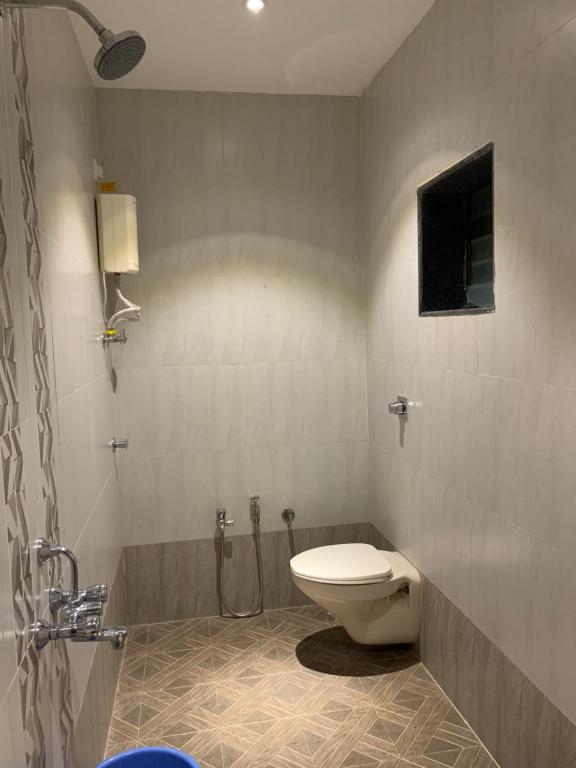 a bathroom with a shower and a toilet in it at Tarkarli Resort Ganpat Prasad in Malvan