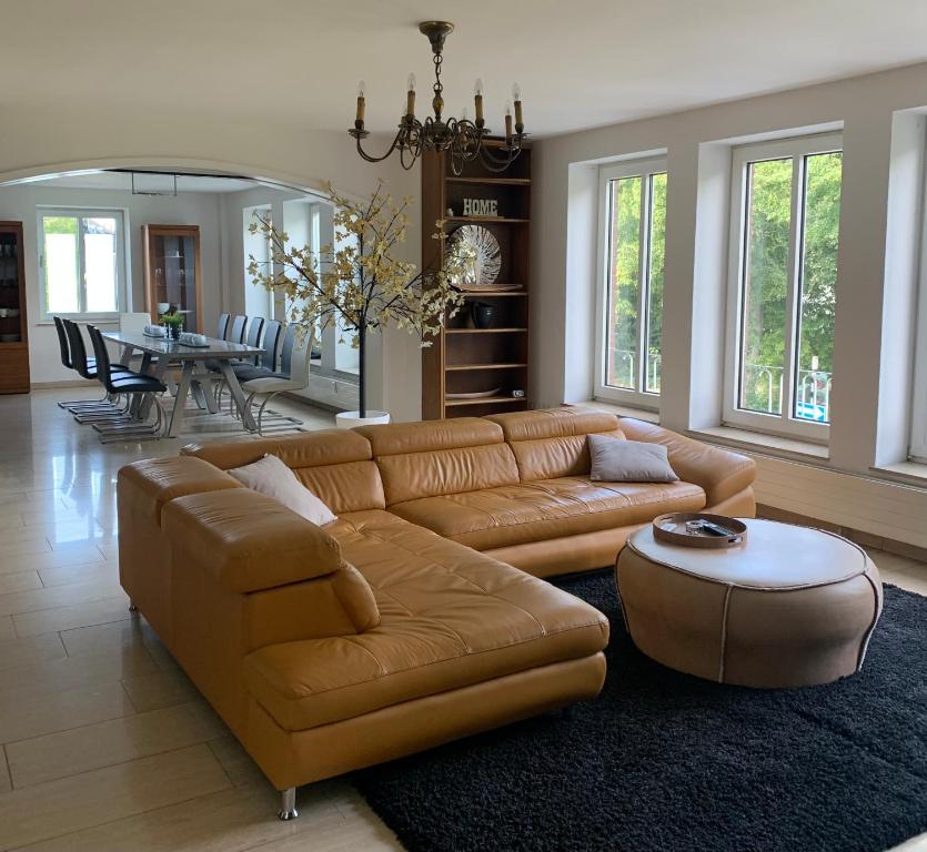 - un salon avec un canapé en cuir brun et une table dans l'établissement Ferienwohnung Mühlenblick, à Kempen