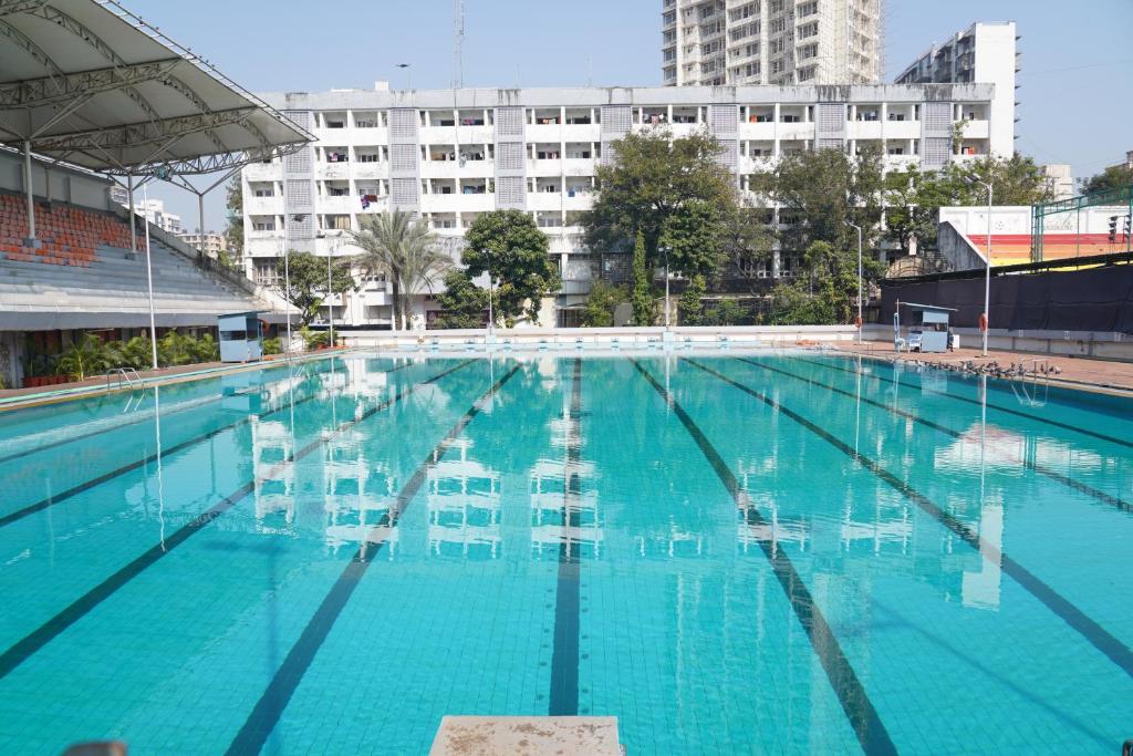 a large swimming pool with blue water in a building at Country Inn by UMRB in Mumbai