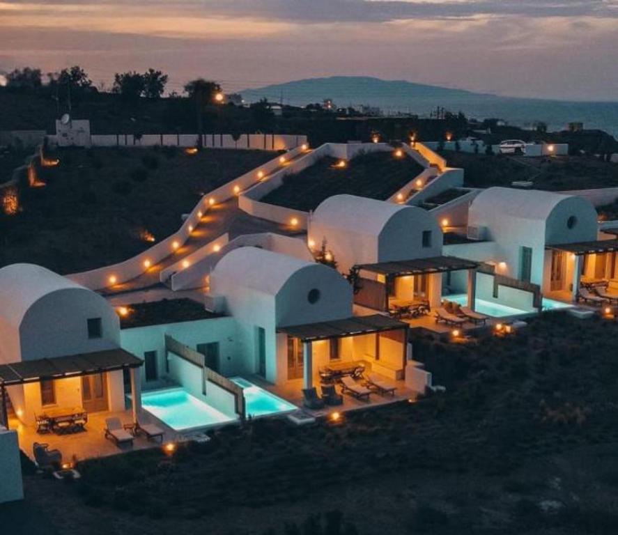 a night view of a large building with lights at Thimari Lodge in Fira