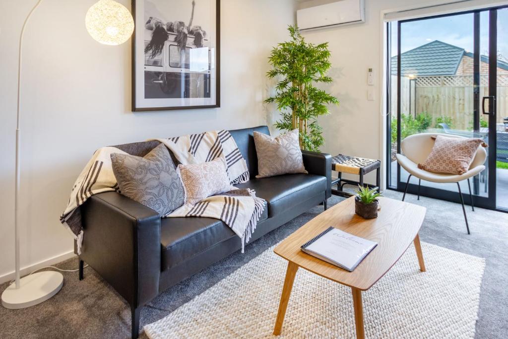 een woonkamer met een bank en een tafel bij Charming Riccarton Abode 2Bed w/Garage in Christchurch