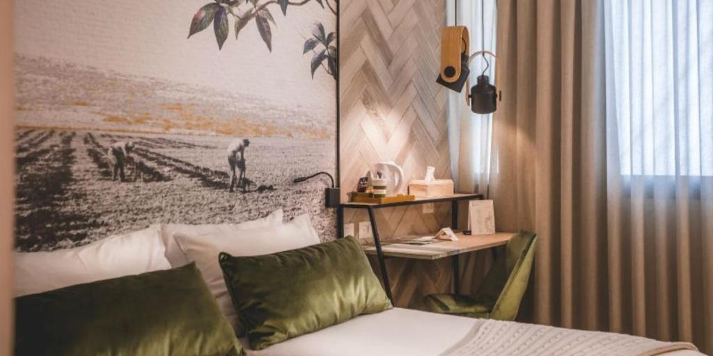 una camera d'albergo con letto e scrivania di Lavi Kibbutz Hotel a Lavi