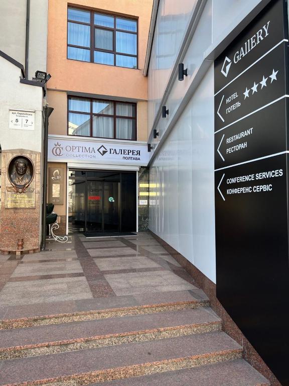 a directional sign in front of a building at Optima Collection Gallery Poltava in Poltava
