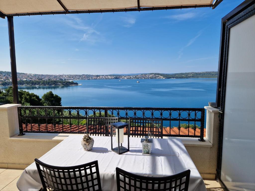 una mesa en un balcón con vistas al agua en Apartments Panorama 2, en Trogir