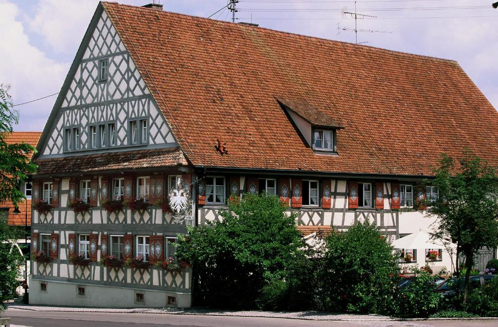 ein altes Haus mit rotem Dach in der Unterkunft Landgasthof zum Adler in Lippertsreute