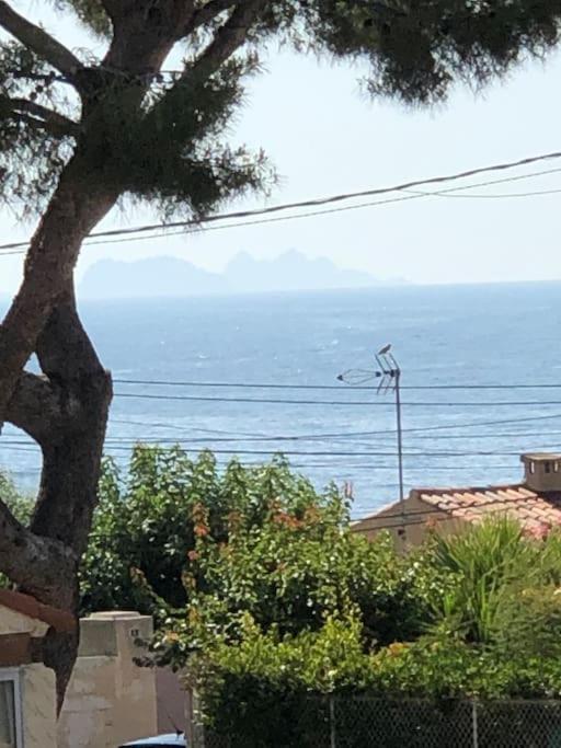 - une vue sur l'océan depuis une maison avec un arbre dans l'établissement Charmante Maison proche d une calanque, à Sausset-les-Pins