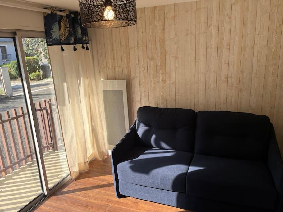 un canapé noir dans un salon avec balcon dans l'établissement Studio rénové dans Saint-Lary, à Saint-Lary-Soulan