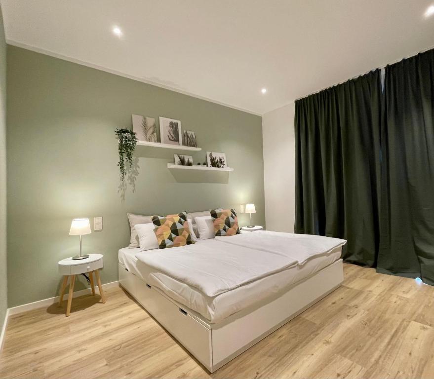 ein Schlafzimmer mit einem großen weißen Bett und einem Fenster in der Unterkunft Condo Apartments Hamburg in Hamburg