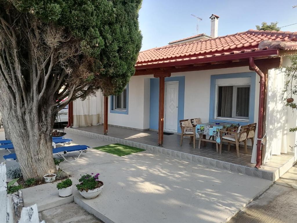 a house with a porch with a table and chairs at Porto Almira Beachfront House in Nikiti
