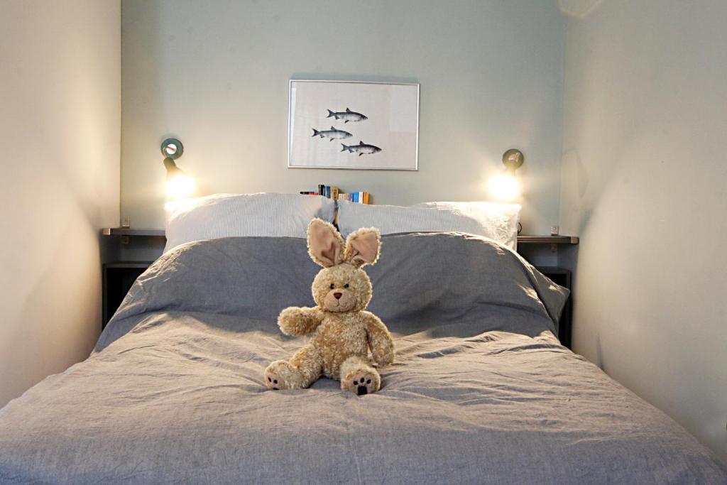 um urso de peluche sentado em cima de uma cama em Bude 1: Liebevoll saniert & komfortabel em Kiel
