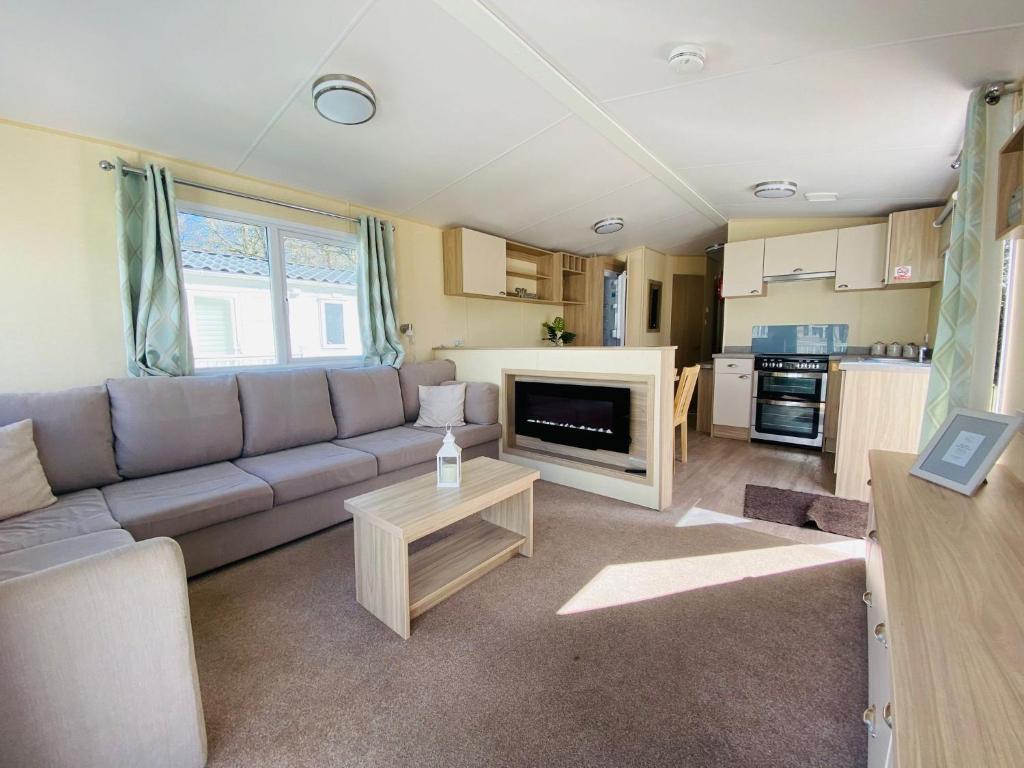 a living room with a couch and a table at New Forest Bees Holiday Home, Bashley in New Milton