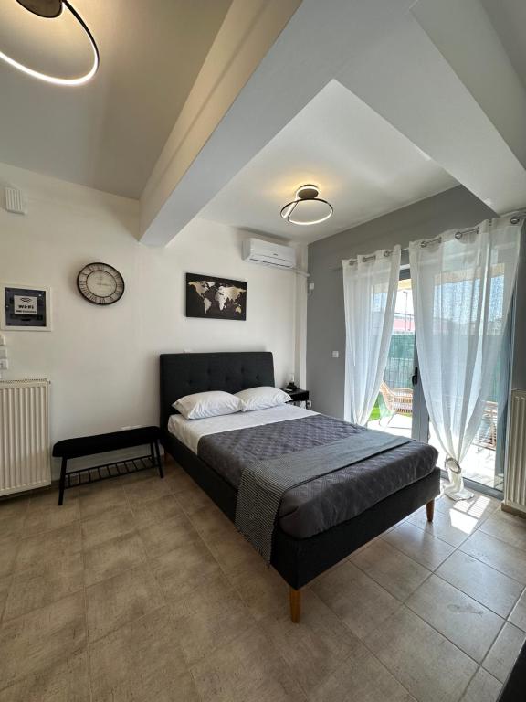 sypialnia z łóżkiem i zegarem na ścianie w obiekcie Elegant Escapes 4 w Atenach