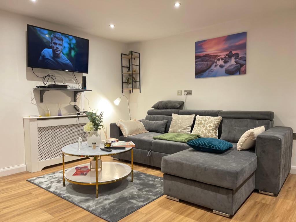 a living room with a couch and a table at Central Cheltenham Apartment in Cheltenham