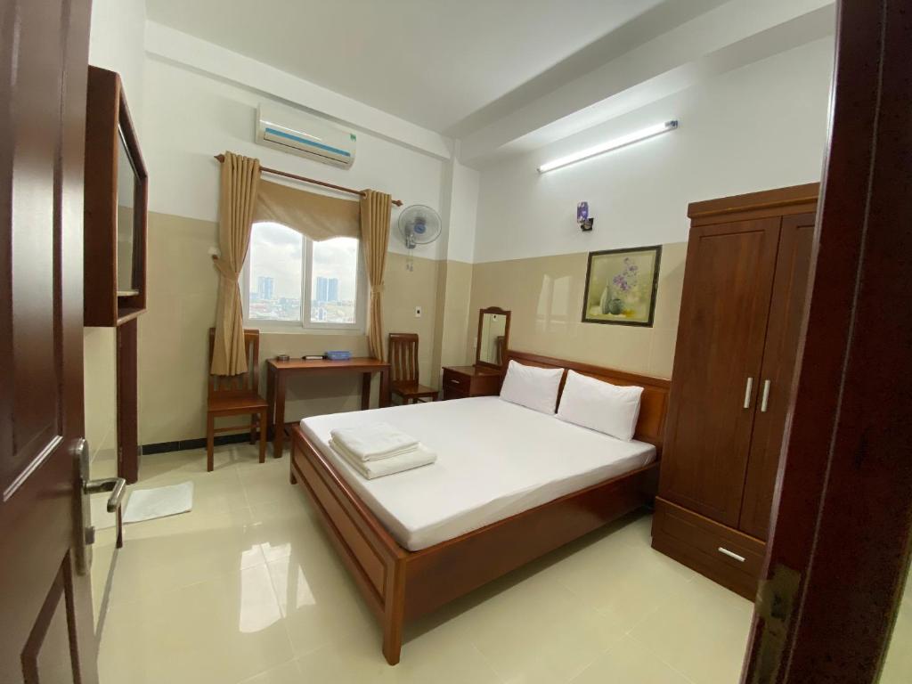 a bedroom with a bed and a desk in it at hotel mỹ việt in Dĩ An