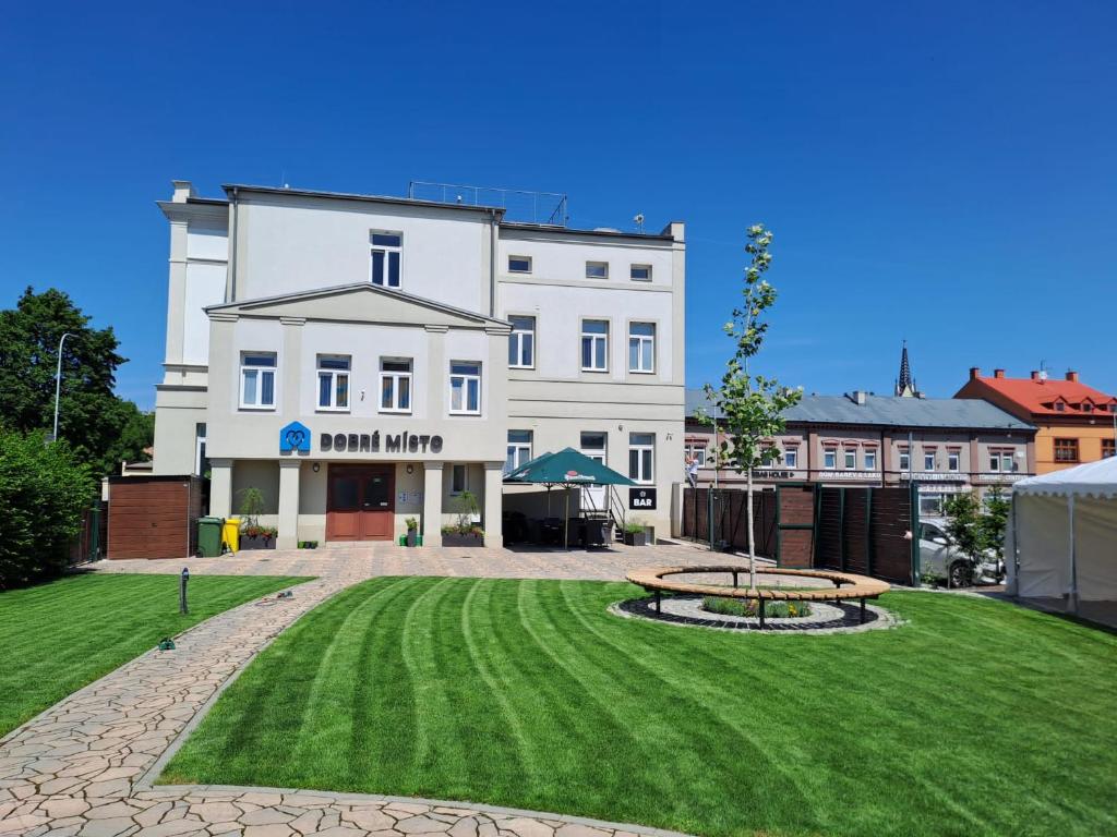 a large white building with a park in front of it at DOBRÉ MÍSTO in Krnov