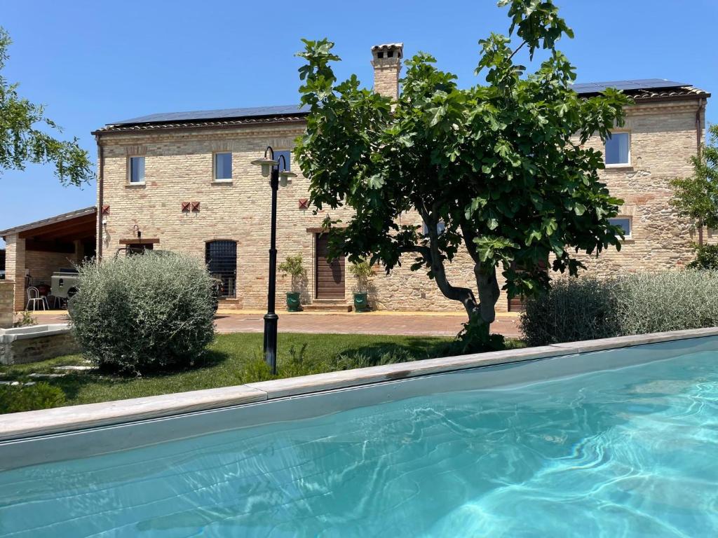 una gran piscina frente a un edificio en SelvaGiurata farmhouse villa, en San Benedetto del Tronto