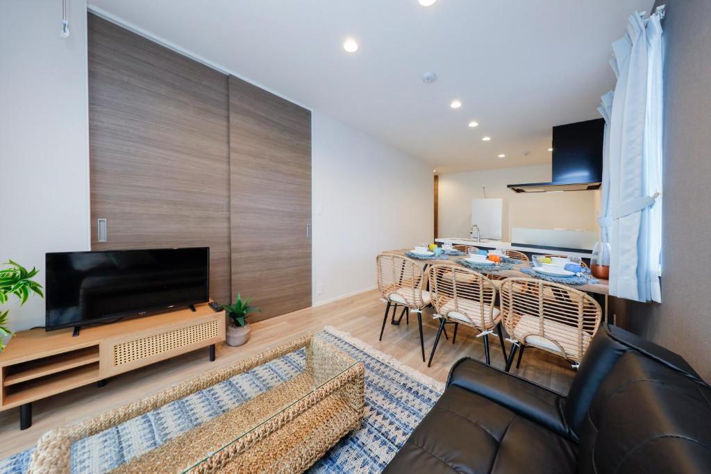 a living room with a table and a large tv at Pacific Coast Enoshima by Tranova in Fujisawa