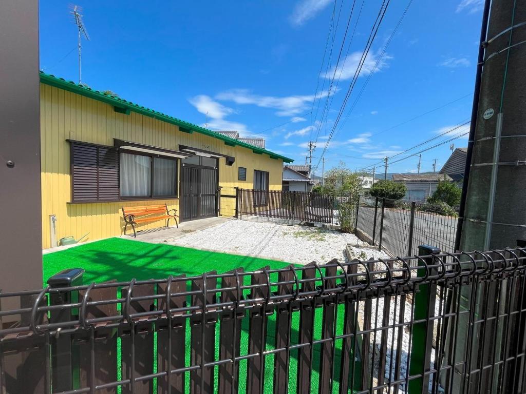 una casa con un césped verde delante de ella en Nobana Mikkabi - Vacation STAY 14751, en Kosai