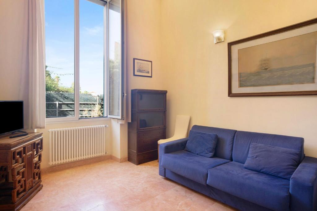 a living room with a blue couch and a tv at Ferrovia, borgo dei pescatori in Cervo
