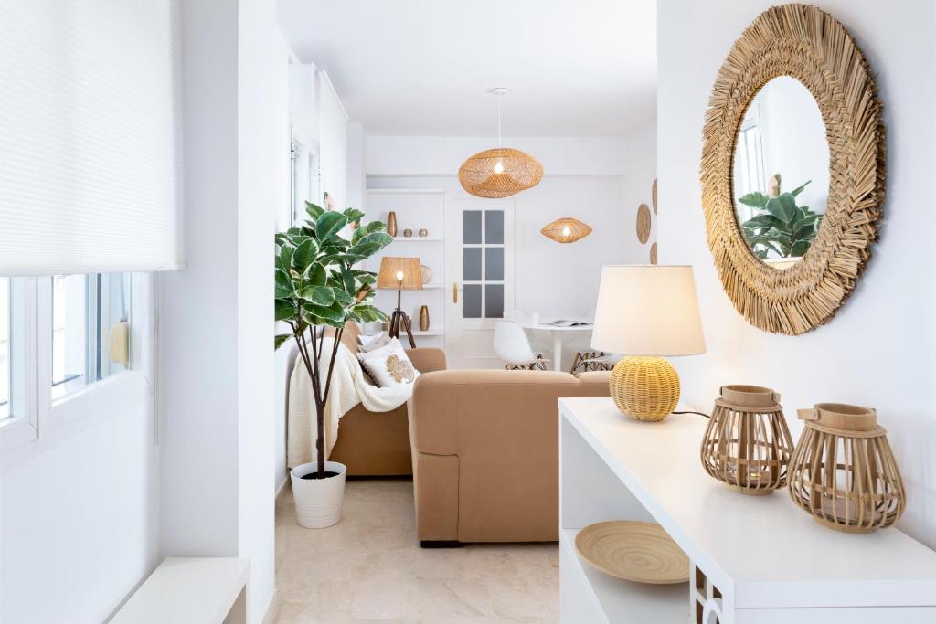 een woonkamer met een bank en een spiegel bij Magno Apartments Alfarería - Private Parking included in Sevilla