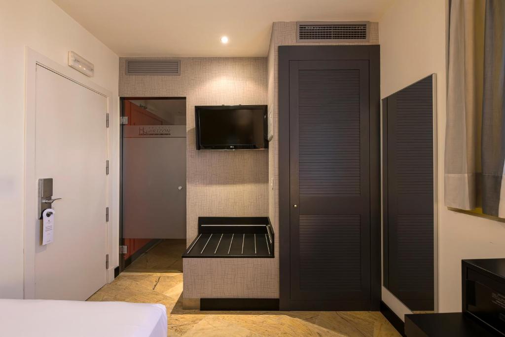 a small room with a television and a door at Hotel Palacio Marqués de Arizón in Sanlúcar de Barrameda