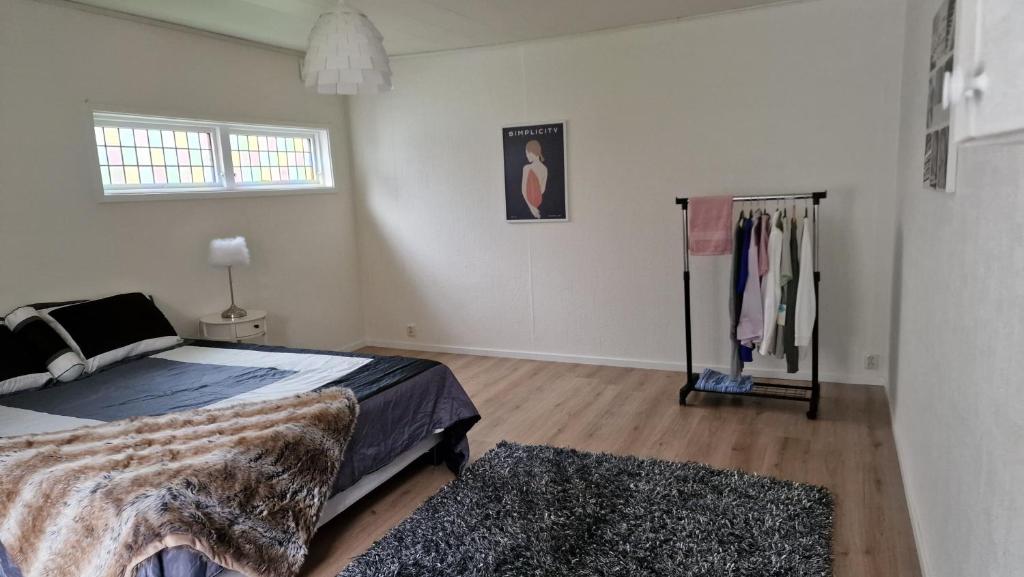 ein weißes Schlafzimmer mit einem Bett und einem Fenster in der Unterkunft Halmstad/Oskarström in Oskarström