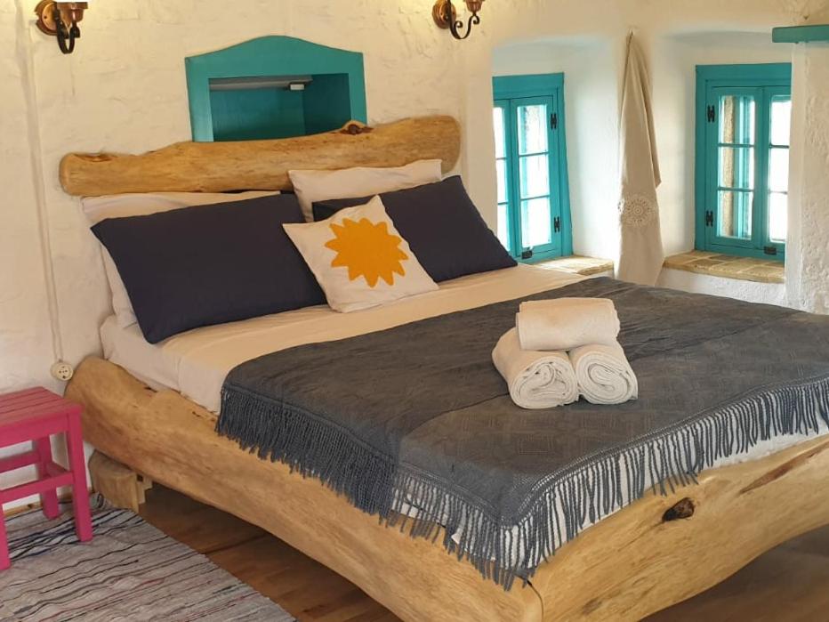 1 dormitorio con 1 cama grande y 2 toallas. en Güneş Butik Otel Datça, en Cumalı