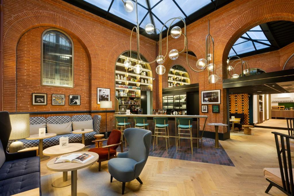 un restaurant avec un bar dans un mur de briques dans l'établissement Hotel Les Capitouls Toulouse Centre - Handwritten Collection, à Toulouse