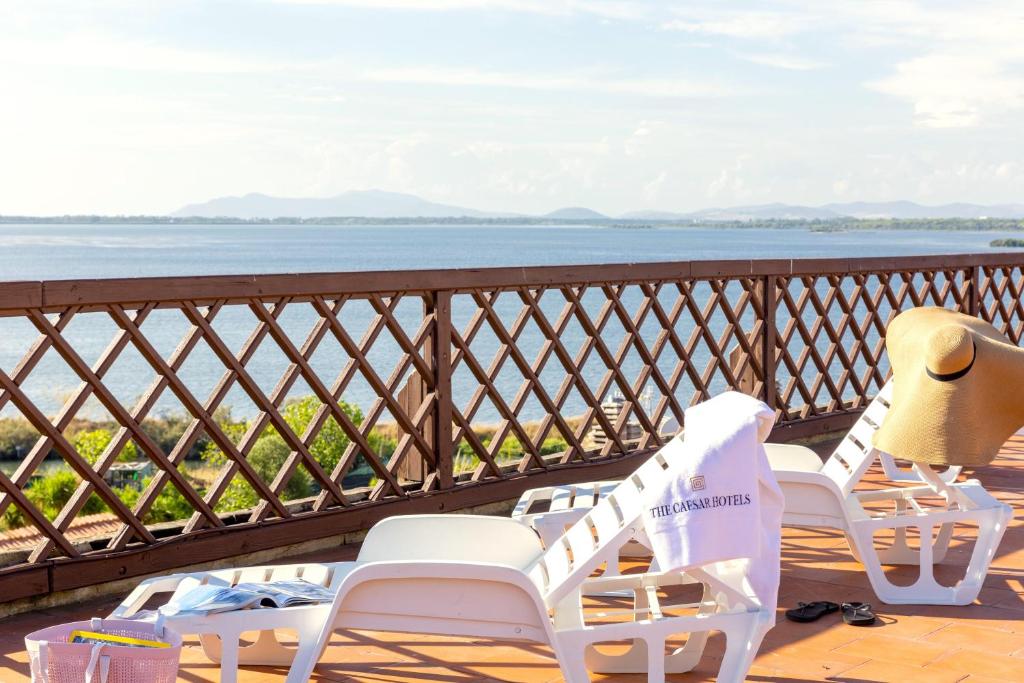 balcón con sillas y vistas al agua en Park Hotel Residence, en Orbetello