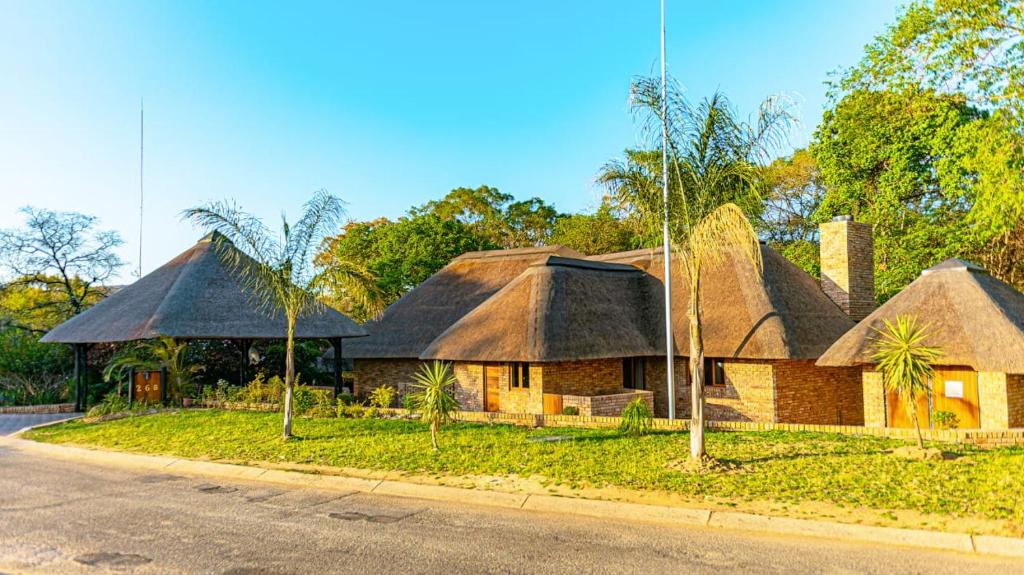 a house with a thatched roof on the side of the road at Kruger Park Lodge Unit 268 - PMP in Hazyview
