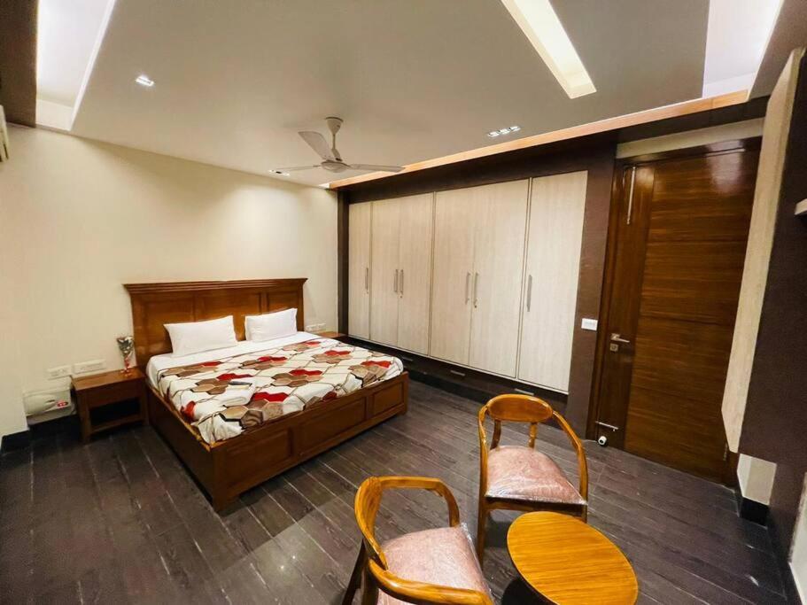 a bedroom with a bed and a table and chairs at Divine India Service Apartment 4Bhk D-163 Saket in New Delhi