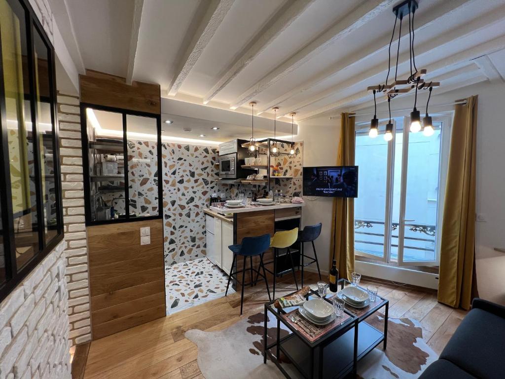 une cuisine et un salon avec une table et des chaises dans l'établissement Appartement Montmartre Sacré Cœur, à Paris