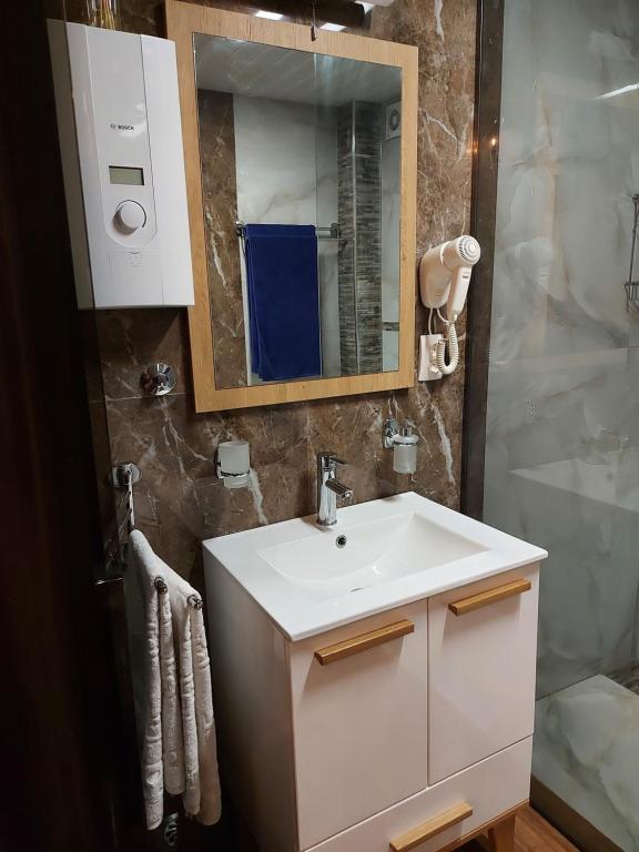 ein Badezimmer mit einem weißen Waschbecken und einer Dusche in der Unterkunft Villa sv.Petka-Ohrid in Ohrid