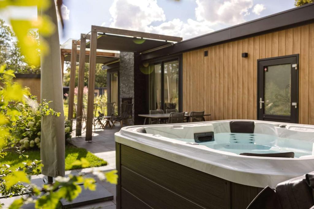 a hot tub in the backyard of a house at Mooi Twente Lodges - privé Spa en sauna in Markelo