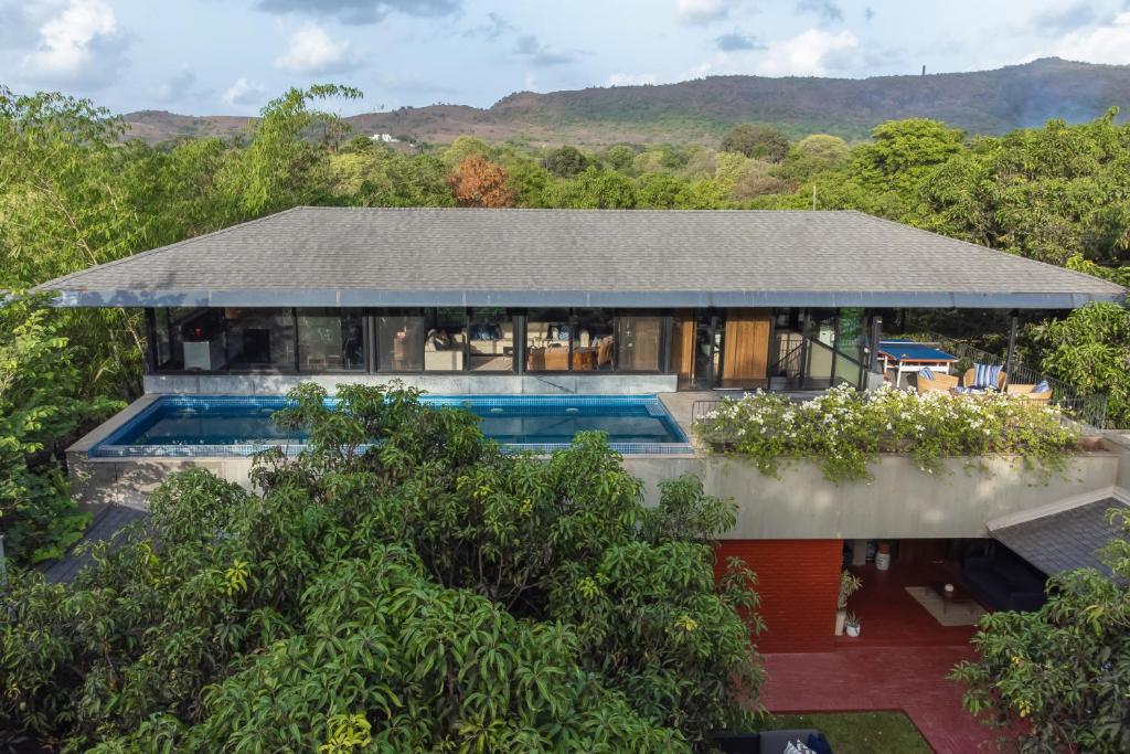 an aerial view of a house with a swimming pool at LohonoStays Villa Orchard House in Revas