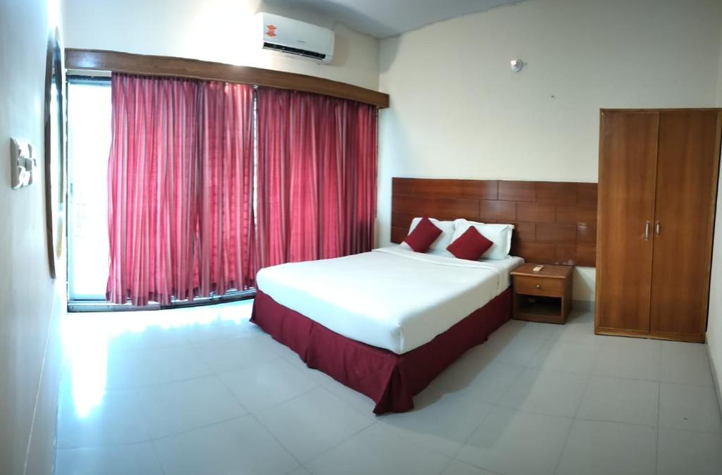 a bedroom with a bed and a red curtain at Castle Bay Touch Cox's Bazar in Cox's Bazar