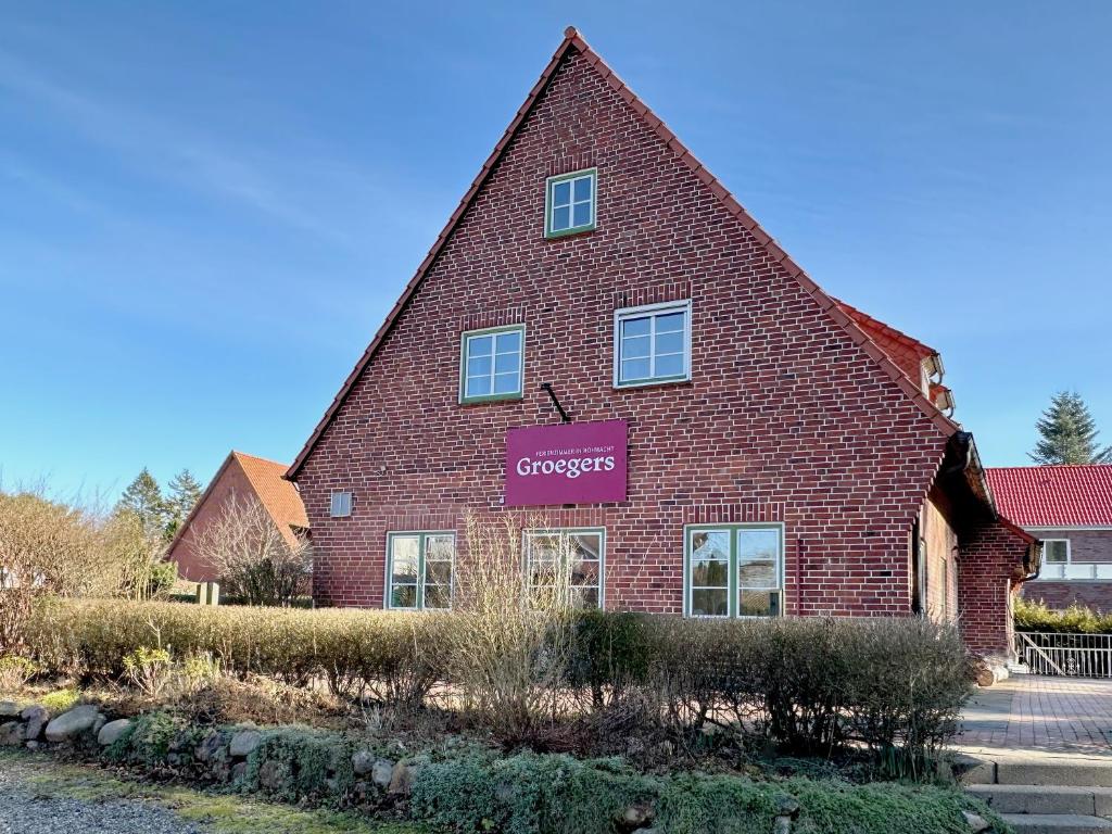 a red brick building with a purple sign on it at Groegers Ferienzimmer in Hohwacht