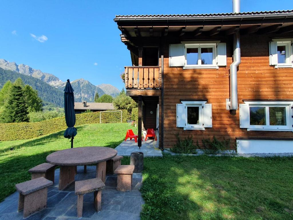 a picnic table in front of a house at Chalet Dalpe by Quokka 360 - chalet among pastures and forests in Dalpe