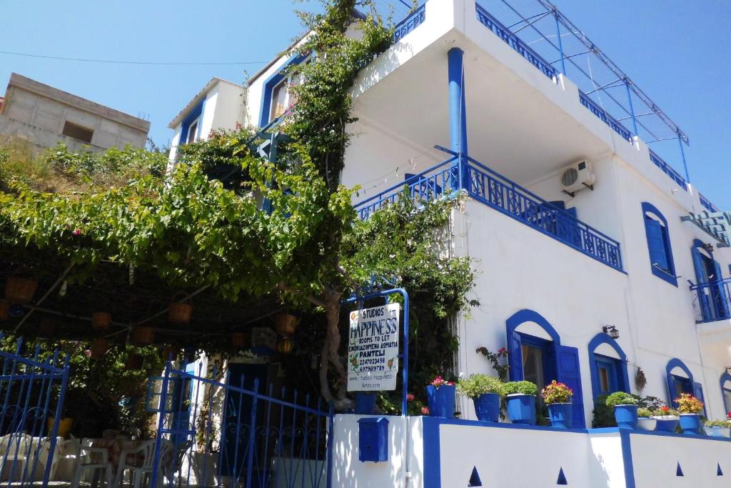 a white building with blue windows and a sign on it at Studios Happiness in Panteli