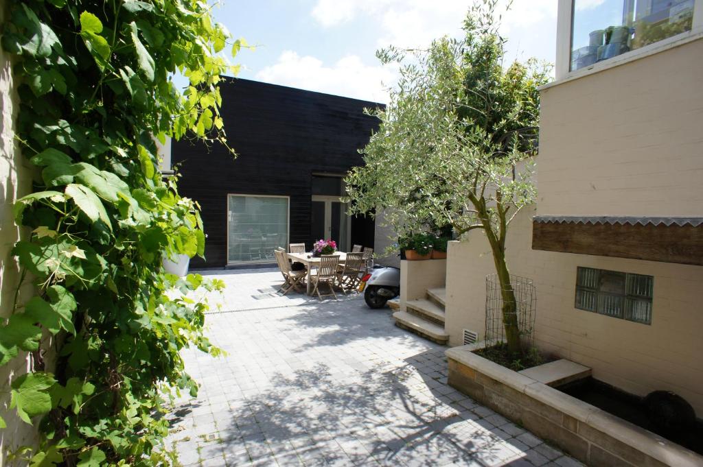 a courtyard of a house with a table and a tree at B&B Wellness Yoake in Ypres