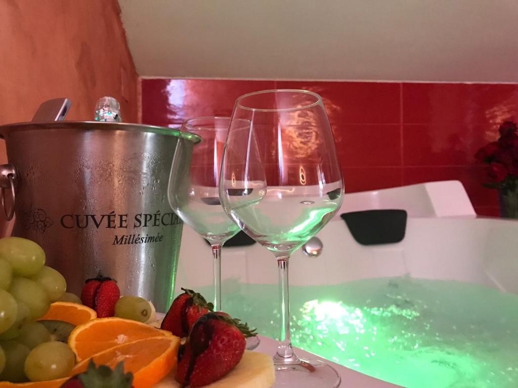 un par de copas de vino sentadas en un mostrador con fruta en Atena B&B APARTMENTS Imperial en San Silvestro