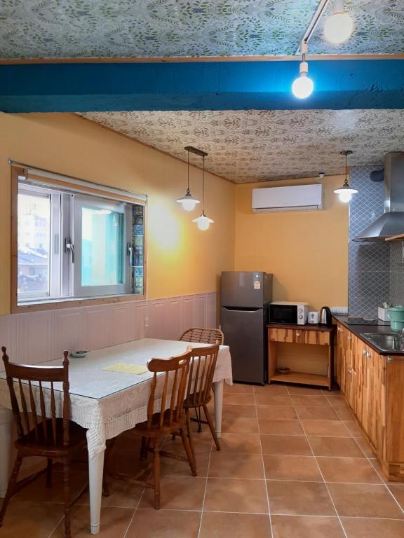 a kitchen with a table and chairs in a room at Deluna House in Mokpo