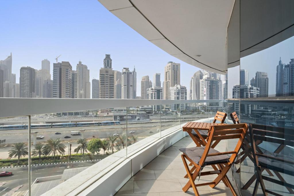 una silla en el balcón con vistas a la ciudad en VayK - Delightful 2BR in JLT with Marina Views en Dubái